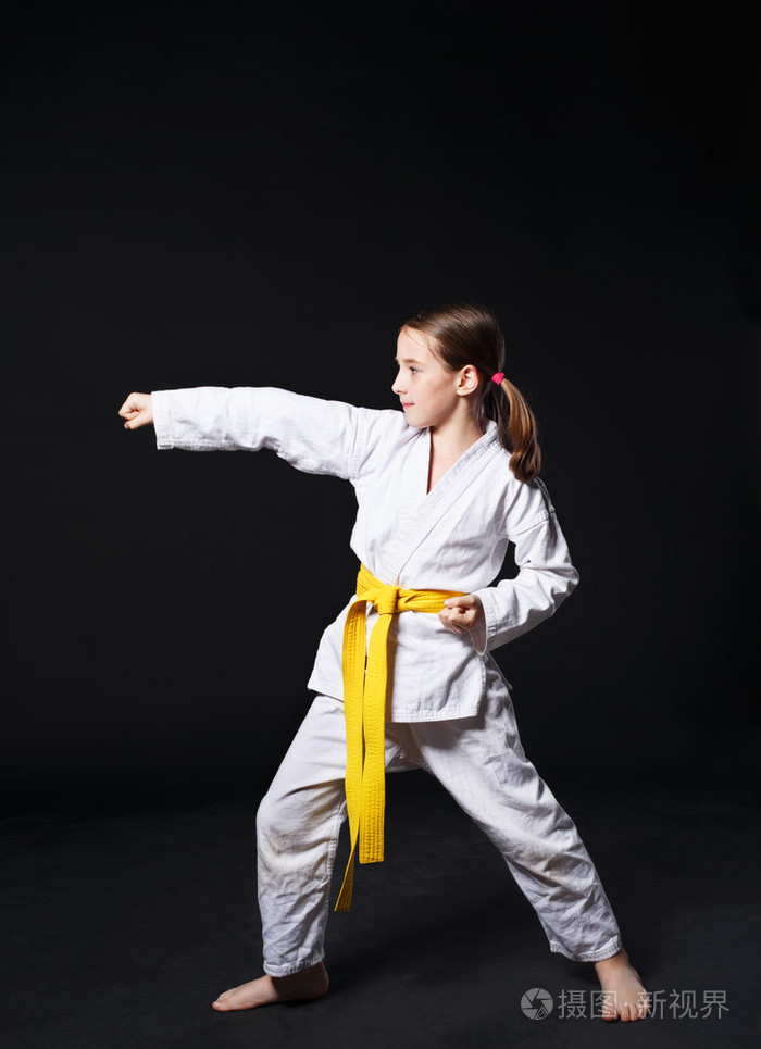 儿童女孩穿着空手道时与黄带表明立场