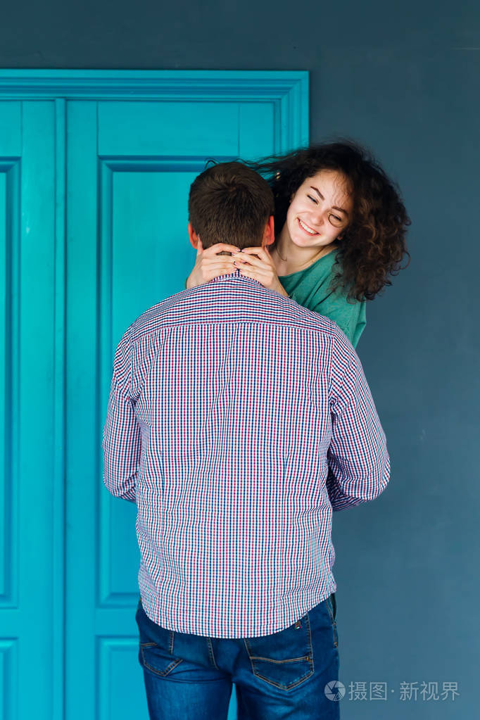 这家伙站在后面抱着他的女朋友在蓝门的背景下