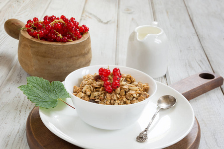 夏季健康早餐的牛奶什锦早餐牛奶壶用红醋栗在木板上的装饰