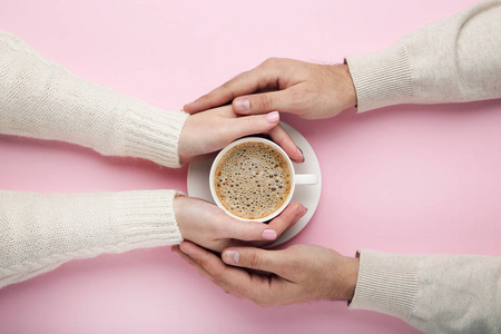 女性和男性手捧杯咖啡在粉红色背景
