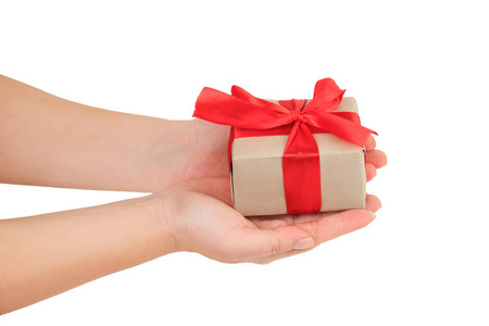 赠送礼物, 女性手在白色背景顶部视图中用红丝带包裹礼物