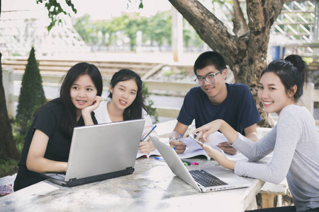亚洲学生小组使用平板电脑和笔记本电脑共享
