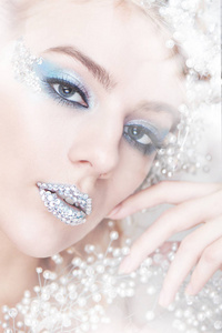 创意化妆和美容主题 一个年轻的女孩与蓝色冬季化妆工作室白色背景