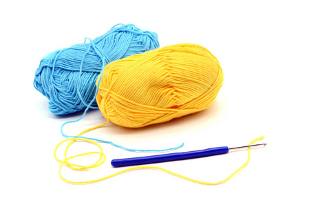 黄色和蓝色羊毛球和钩针白色隔离