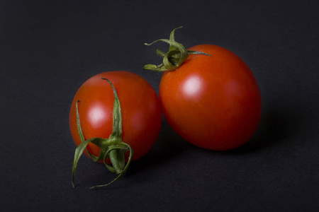 红色的西红柿在黑暗的背景。黑暗背景下的两个红色西红柿