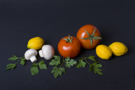黄色胡椒和柠檬和西红柿在黑暗的背景。黑色背景下番茄和黄柠檬菇的组成