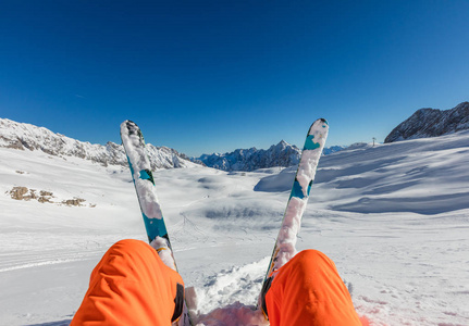 滑雪者坐在粉雪中, 看高山风景