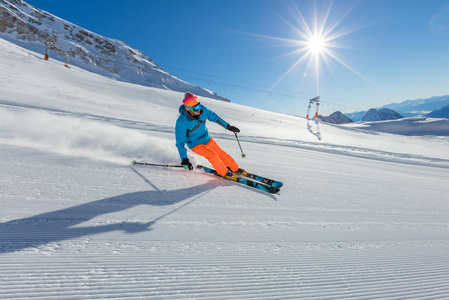 高山景观下滑雪跑下坡的滑雪者