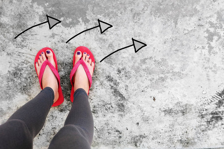 紫罗兰指甲修脚女子凉鞋脚与箭头绘制选择方向水泥背景
