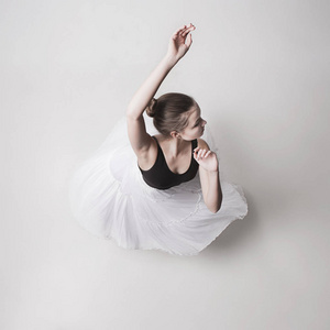白色背景下的青少年芭蕾舞女演员的最高观
