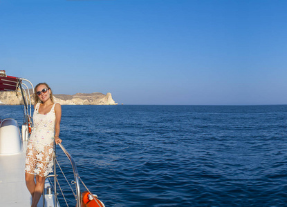 在岛上日落时乘船旅行的妇女。夏季 Sntorini, 希腊
