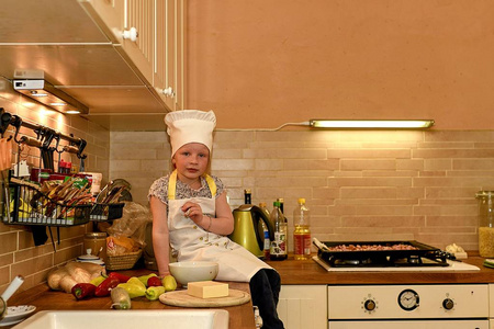厨房里戴着大厨帽的小女孩小女孩准备比萨饼