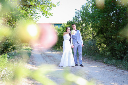 年轻的新娘和新郎在婚礼当天在大自然中漫步