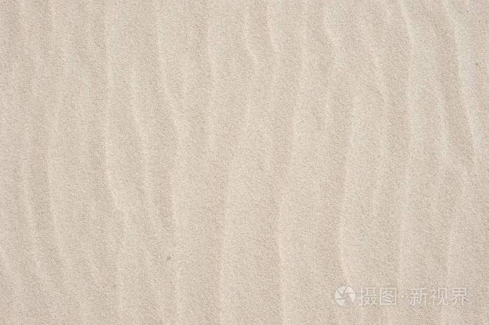 背景和纹理.海滩上未接触的干沙子的特写图片;强风发出的柔和波浪