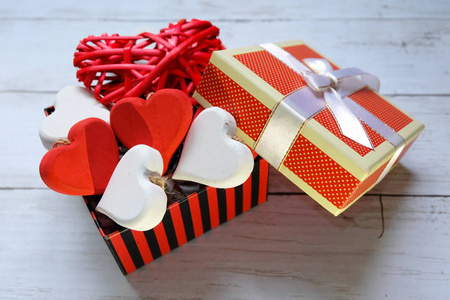 白色木制背景下的打开盒上的红色木制手工心脏符号的顶部视图。情人节主题