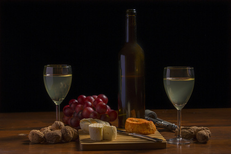 组成与酒 奶酪 坚果和木制的桌子上的葡萄