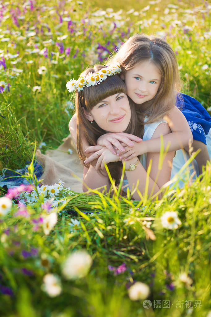 妈妈和女儿在洋甘菊田里野餐.