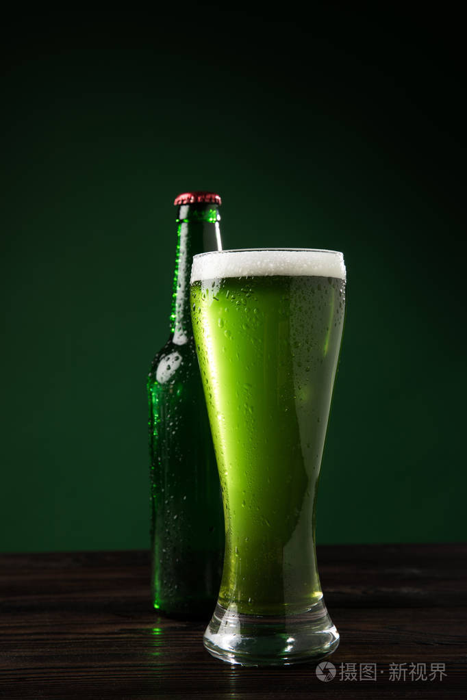 玻璃瓶和绿色啤酒在桌上, st 帕特里克天概念