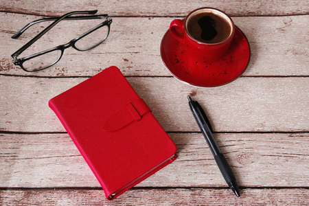 木桌上的咖啡日记本和眼镜