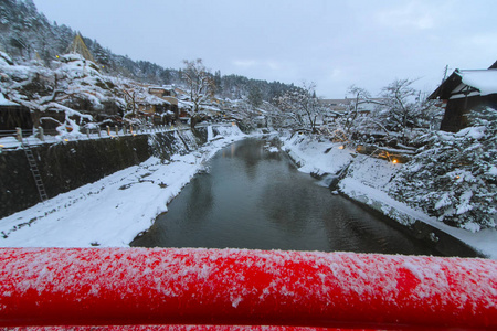 宫川河盖与雪和古董大厦看法从红色桥梁看从地方日本样式房子附近 Nakabashi 桥梁沿边的高山看法