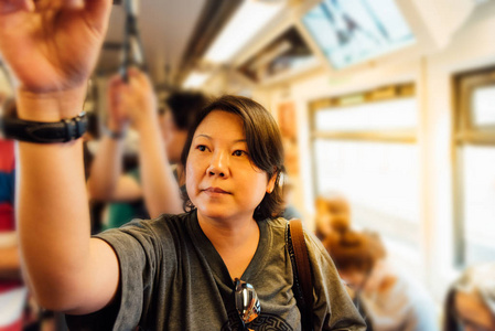 亚洲女子乘坐轻轨列车在城市图片