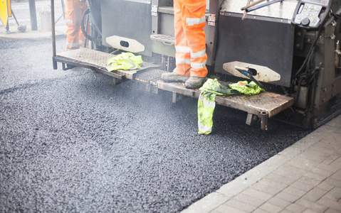 街道新沥青与工人的道路工程