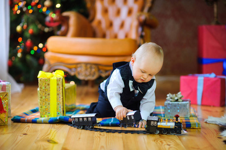 美丽的孩子玩他的新礼物在地板上的房间里, 在背景的圣诞佳节