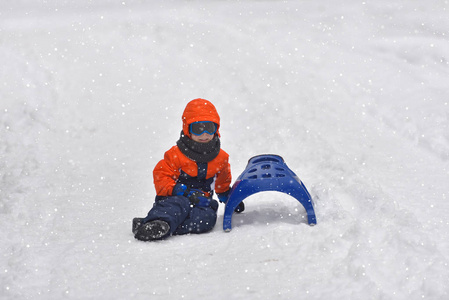 冬天的时候, 小男孩在雪地上滑行