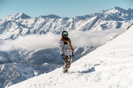 滑雪女运动服站在高山山峰上