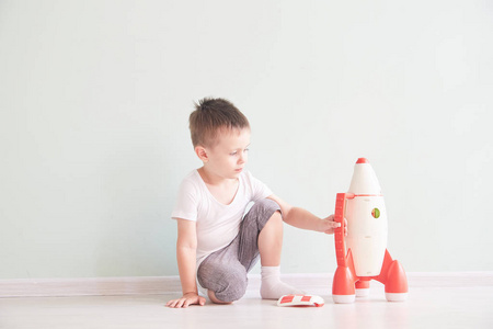 活泼的小男孩玩火箭玩具, 孩子显示火箭玩具与愉快的面孔, 孩子或幼儿学习和发展概念