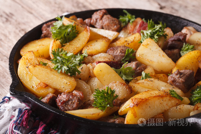 炸土豆加肉和培根在平底锅里,很近. 水平水平