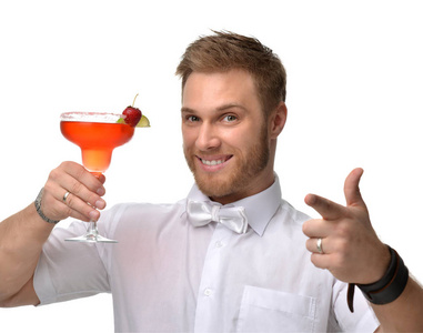 年轻人与红色草莓玛格丽塔鸡尾酒喝果汁高兴地指向一根手指照片