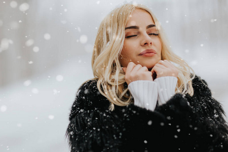 美丽的年轻金发女子在白雪皑皑的冬日