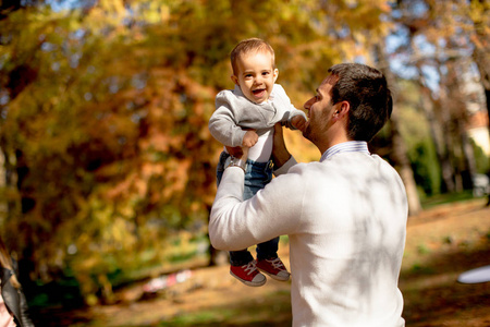 秋天公园的年轻的父亲和男婴