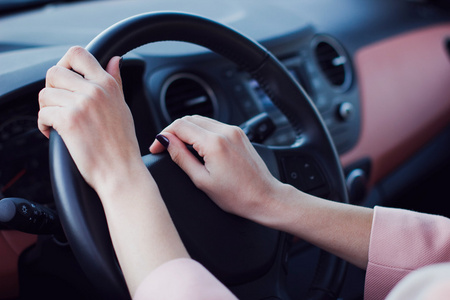 女人的手放在车的方向盘上按下按钮