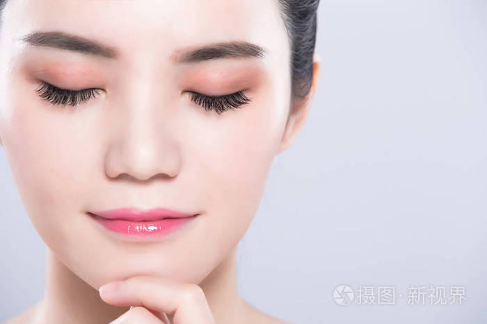 灰色背景的闭着眼睛的妇女