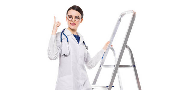 年轻的女医生与听诊器站在梯子上, 指着她的手指