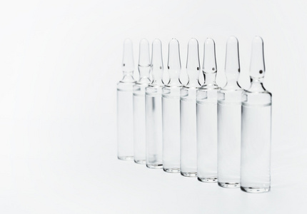 用液体药装在白色背板上的密封玻璃安瓿照片