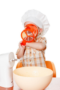 可爱的小宝贝一个厨师的帽子，准备鸡蛋的一餐。孤立对白色