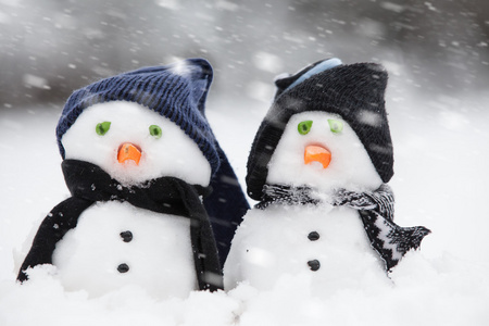 两个可爱的雪人,冬天穿着照片