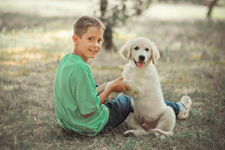 猎犬可爱的场景帅少年男孩享受暑假与最好的朋友狗象牙白色拉布拉多小狗。地无忧无虑的童年生活在梦幻世界