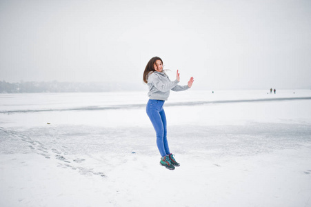 冬日冰冻湖面上的滑稽跳跃女孩