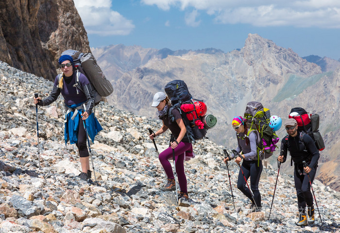 一群登山者在荒凉的岩石地形上行走照片-正版商用图片0fahwd-摄图新