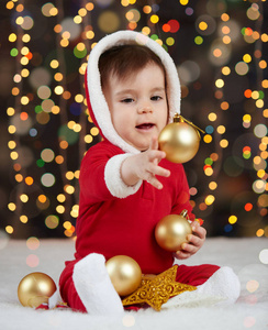 小男孩装扮成圣诞老人玩圣诞玩具, 深色背景照明, 新年快乐和寒假概念