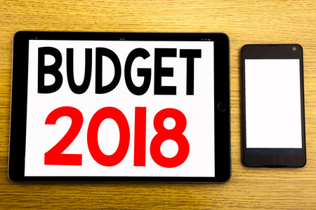 文字显示预算2018。家庭预算会计规划的经营理念写在石板上, 木制背景与粘纸条和钢笔