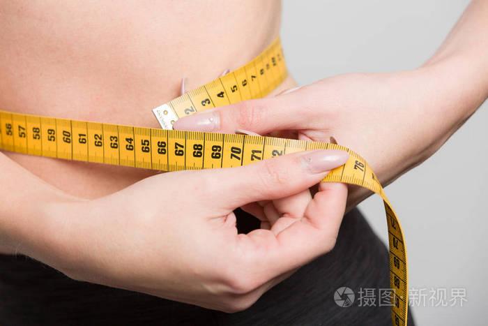 年轻女子用按摩带测量腰围