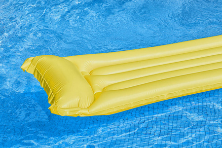 漂浮在游泳池中的蓝色气垫床垫图片