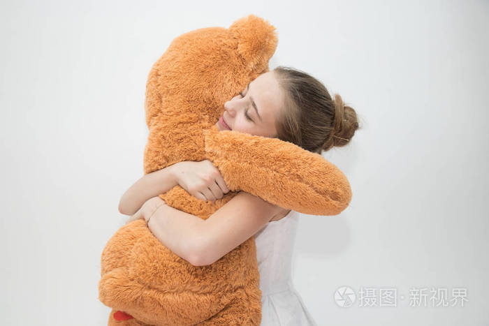 拥抱一只大泰迪熊的年轻女孩
