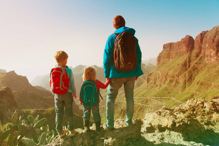 父亲和两个孩子在山上爬山照片
