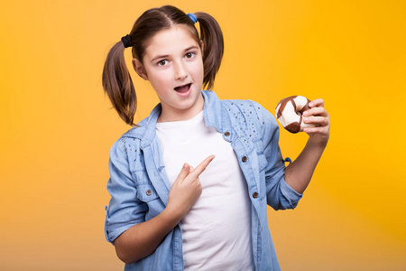 富有表现力的年轻女孩 poiting 在一个甜甜圈, 她手里握着